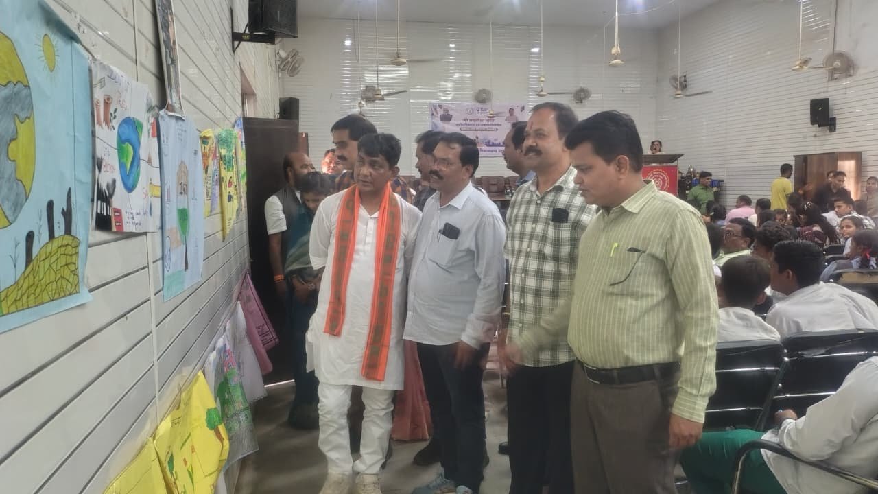 प्रदर्शनी में बच्चों द्वारा बनाई गई चित्रकलाकृतियों का अवलोकन करते अतिथि।
